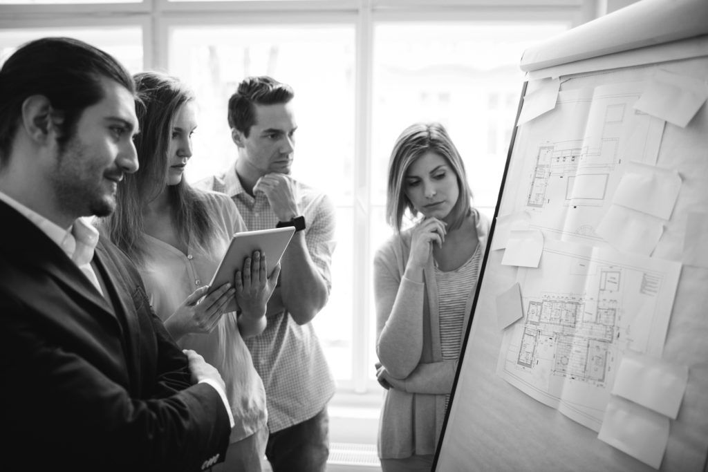 consultants working in office looking in flipchart