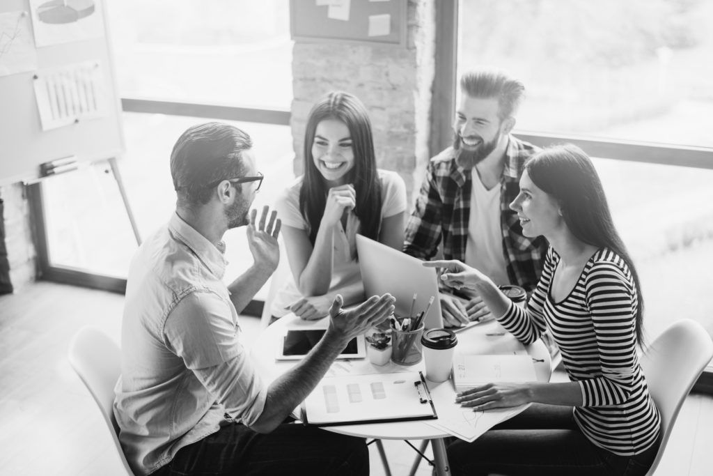 people talking at desk in office
