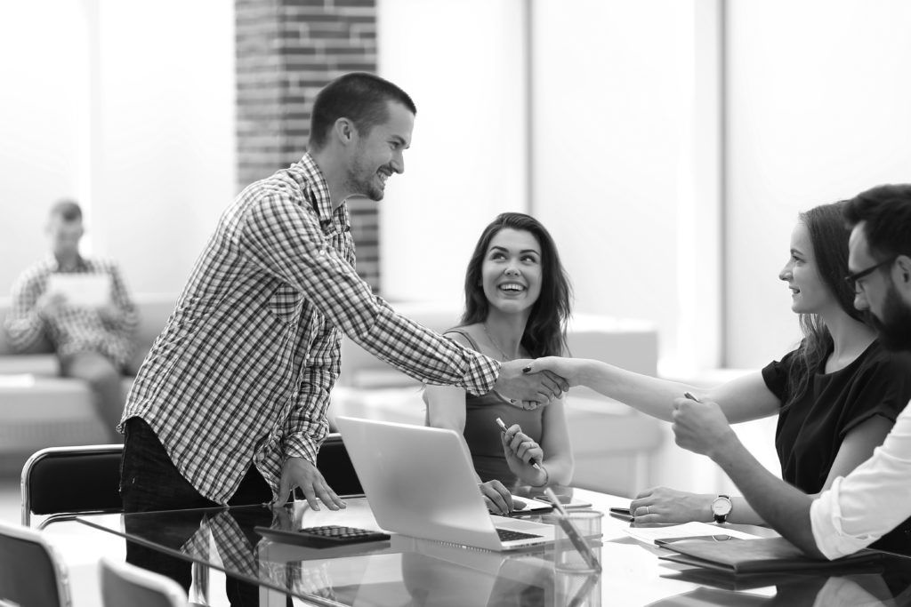 consultants shaking hands in front of group