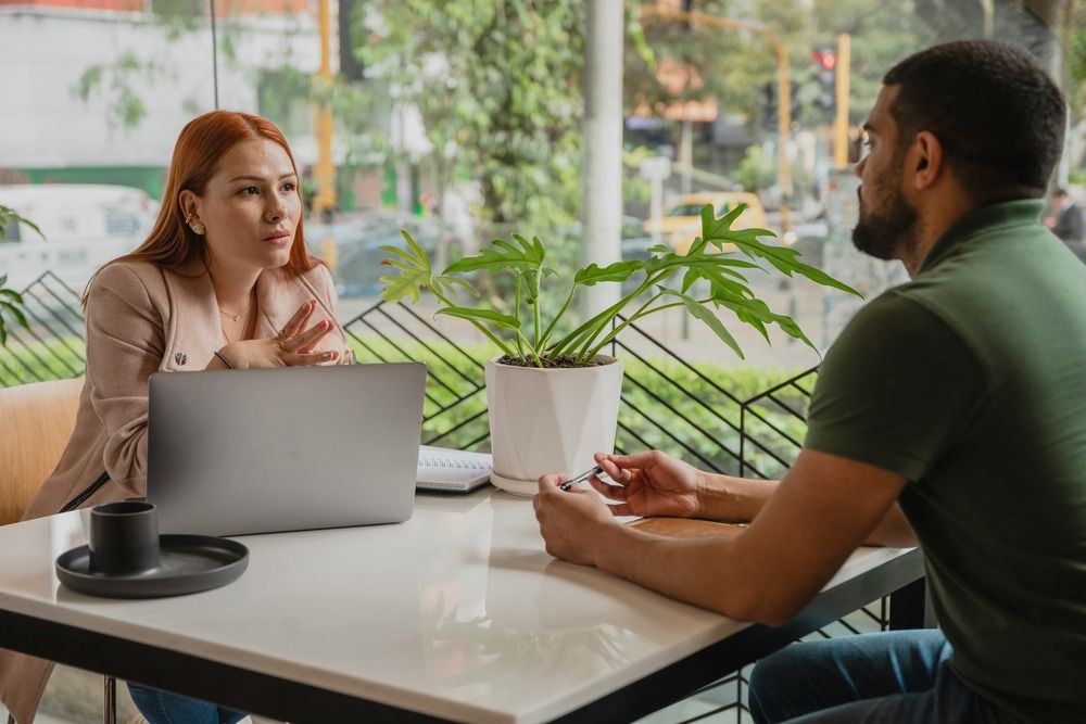 a-man-and-a-woman-sitting-at-a-table-with-a-laptop
