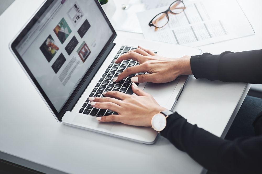 Hands typing on a computer.